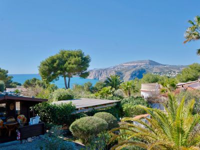 Panoramablick auf Jávea mit Holzhütte und üppigem Grün.