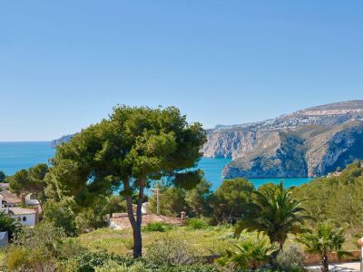 Panoramablick auf Jávea mit üppigem Grün und dem Mittelmeer im Hintergrund.