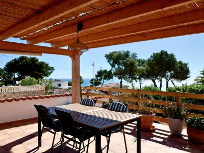 Überdachte Terrasse mit Esstisch und Meerblick in Jávea.