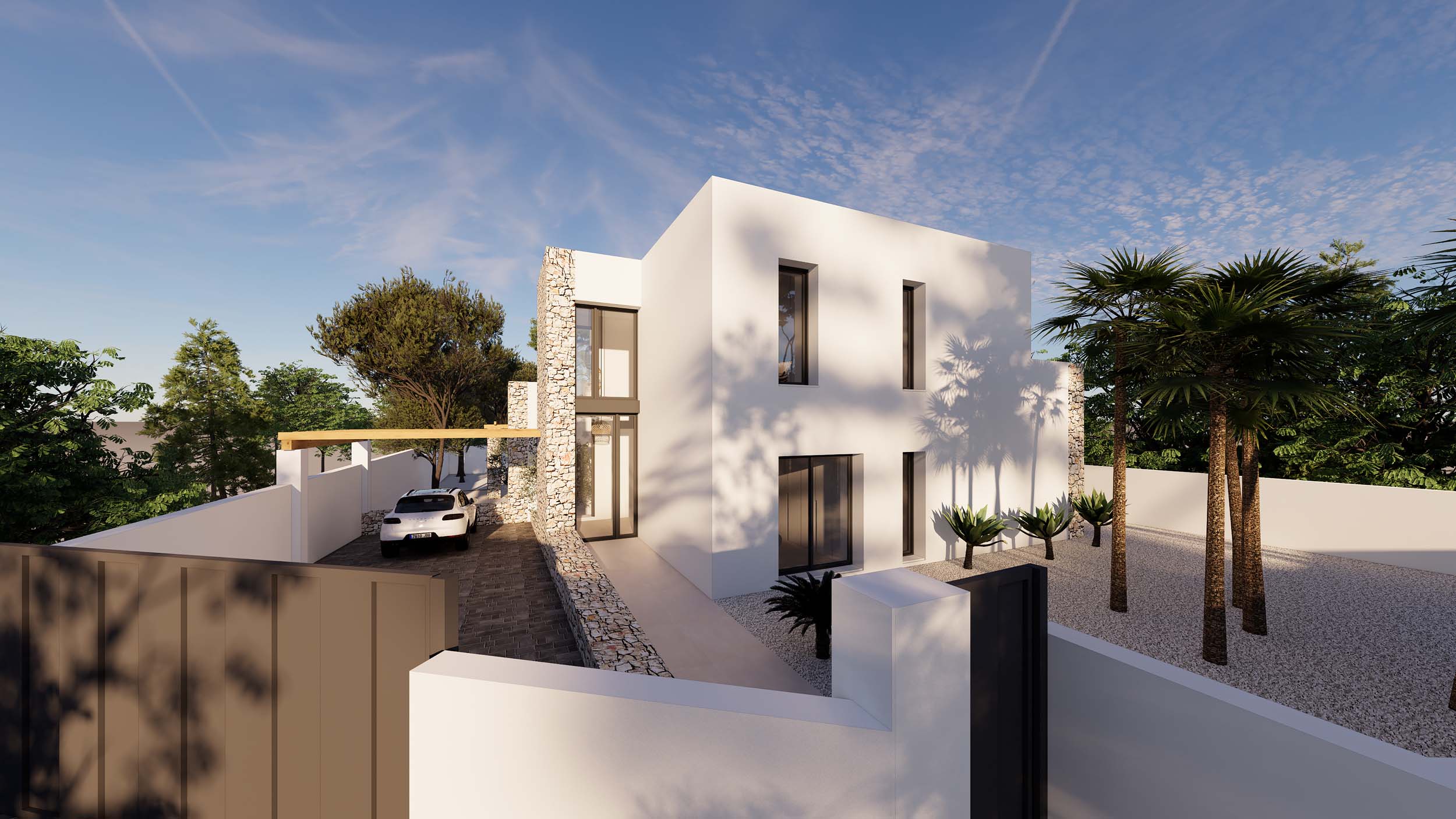 Außenansicht im Ibiza-Stil mit Natursteinwänden, weißer Architektur und Kiesgarten mit Palmen. Die gepflasterte Einfahrt führt zu einem Parkplatz mit Pergola.