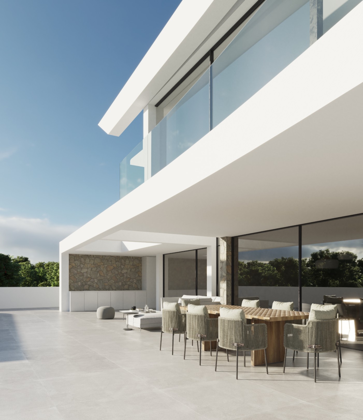 Außen-Terrasse mit Esstisch aus Holz und geflochtenen Stühlen unter einer minimalistischen weißen Fassade mit Natursteinakzenten und Glasgeländern.