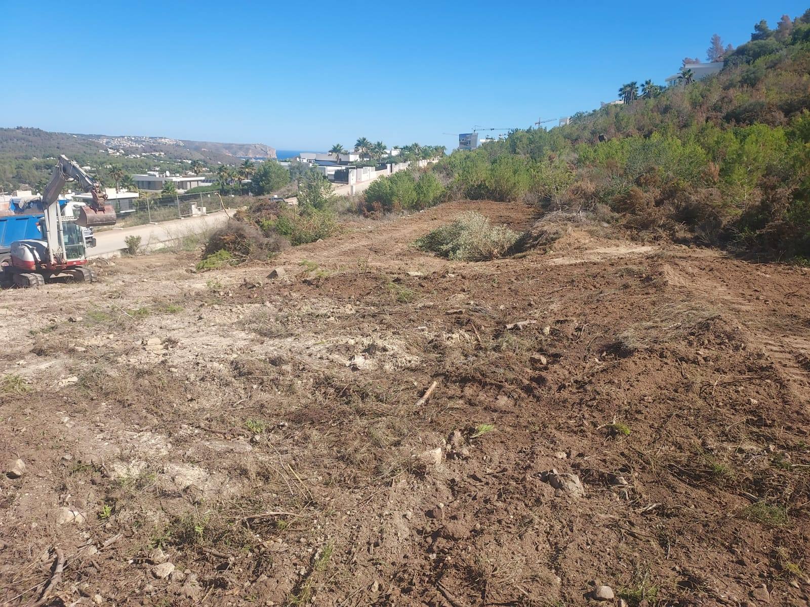 Grundstück in Jávea in Vorbereitung mit Bagger und Meerblick.