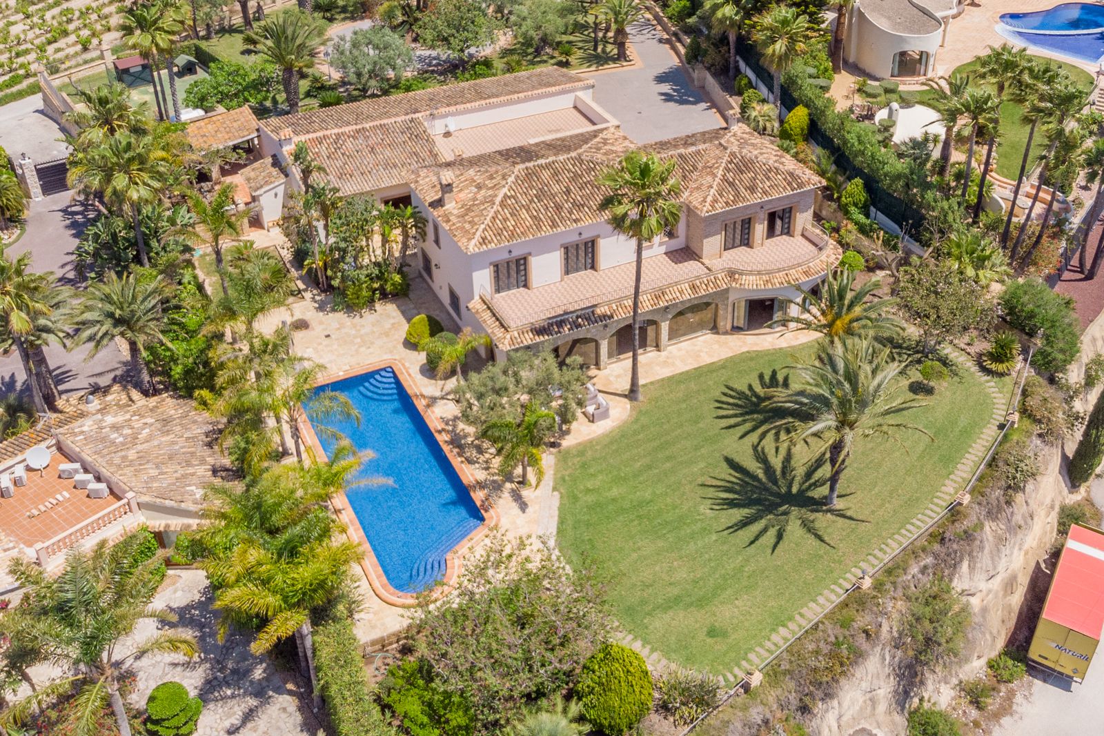 Luftaufnahme des Anwesens mit blauem Pool, üppigen Gärten und mediterraner Architektur.