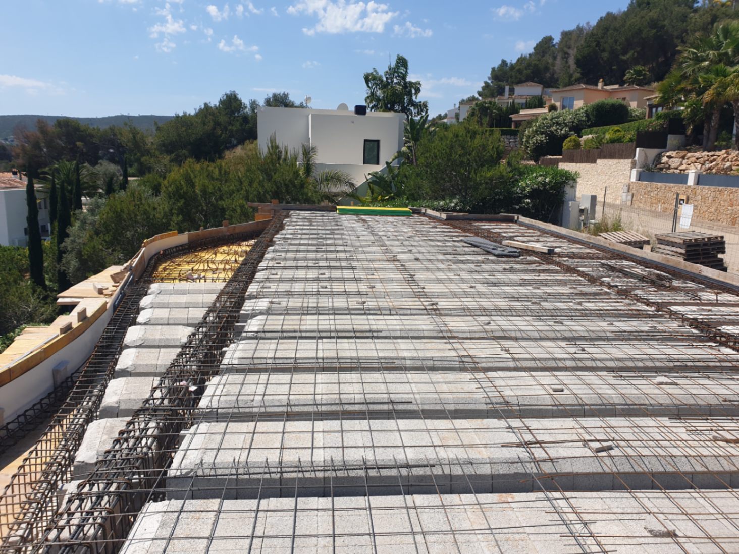 Aktueller Baufortschritt der Deckenkonstruktion mit Betonsteinen und Stahlbewehrung auf einem erhöht gelegenen Grundstück in Jávea.