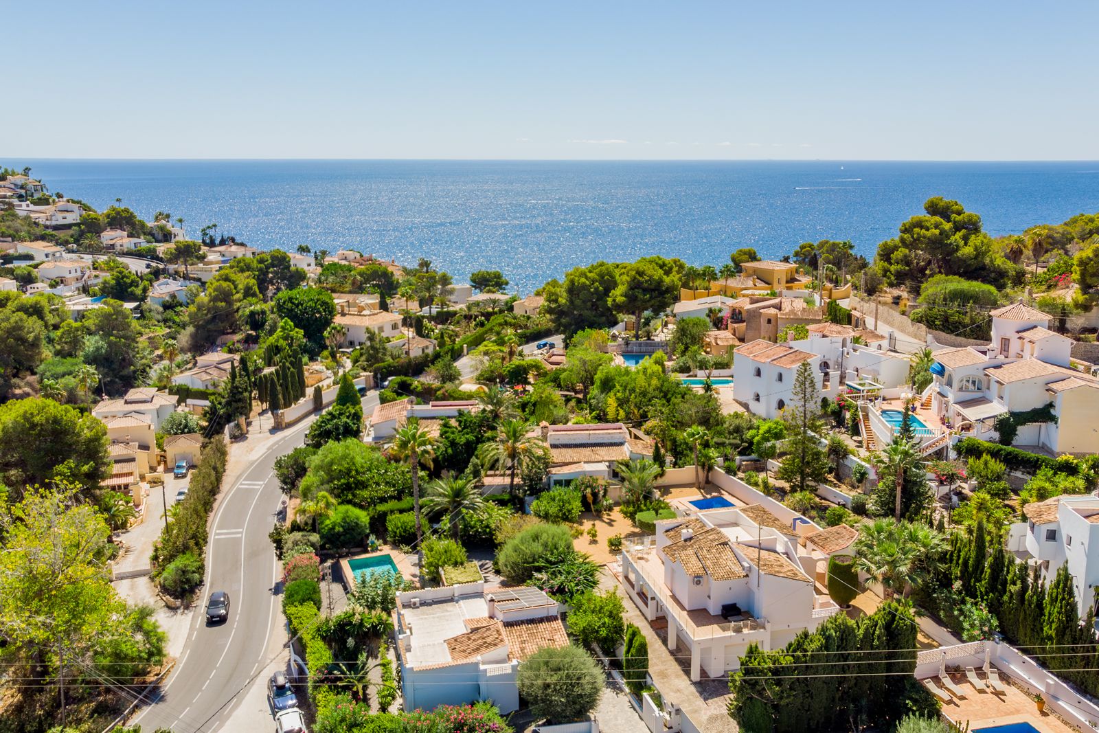 Panorama-Luftaufnahme des Küstengebiets von Baladrar, die die Nähe zum Mittelmeer und die üppige Landschaft mit traditionellen weißen Villen zeigt.