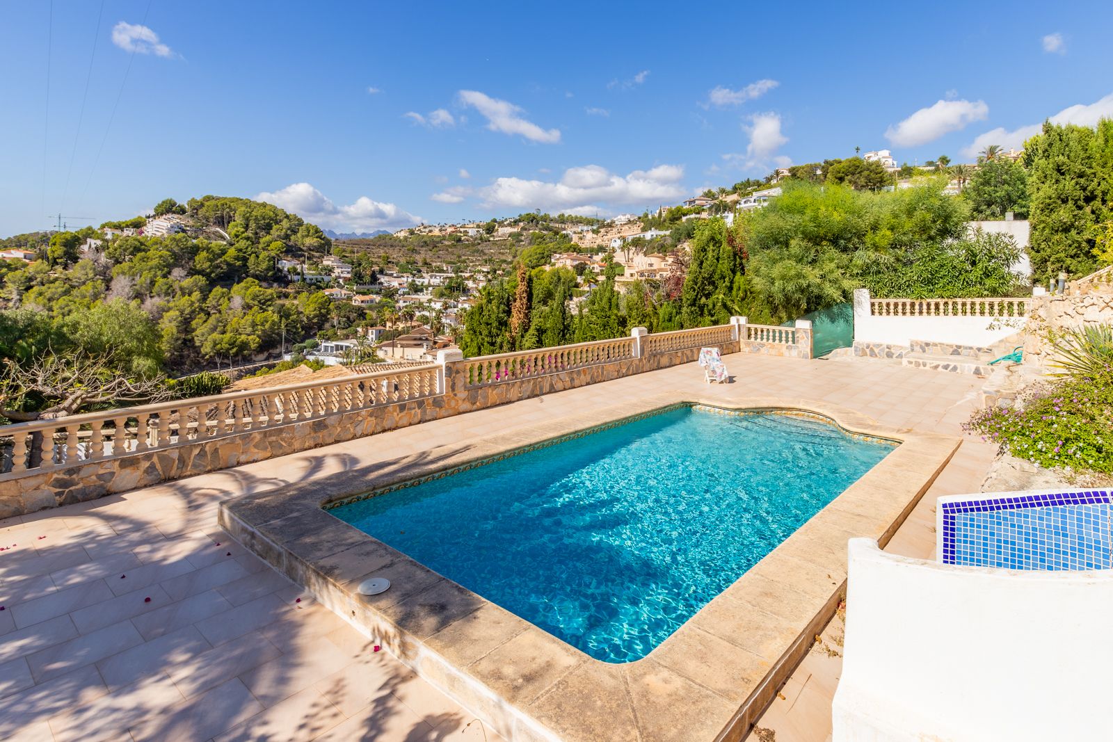 Privater rechteckiger Pool auf einer Steinterrasse mit klassischer Balustrade und weitem Panoramablick über die bewaldete Hügellandschaft von Benimeit.