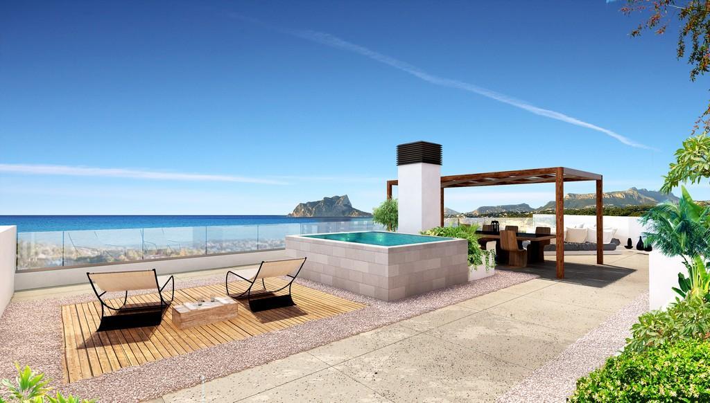 Dachterrasse mit erhöhtem Pool, Essbereich unter einer Holzpergola und Panoramablick auf das Mittelmeer und den Peñón de Ifach.