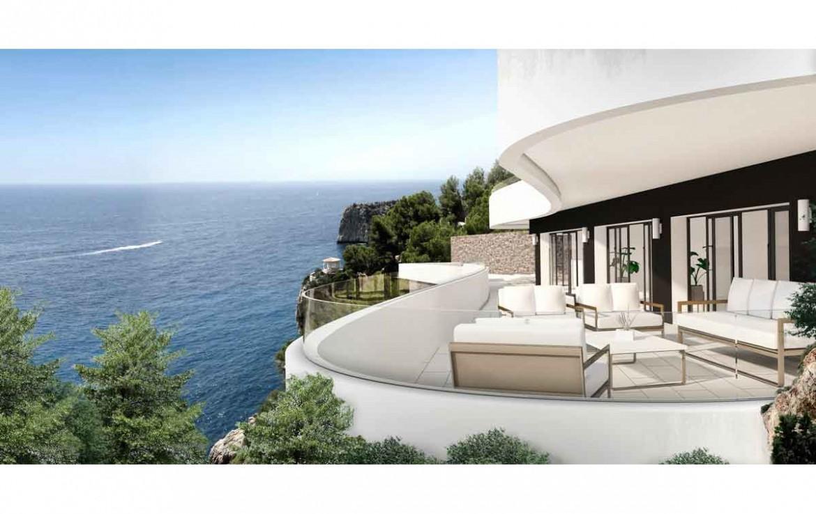 Geschwungene Terrasse mit Glasgeländer und modernen Außenmöbeln mit Blick auf das Mittelmeer und die Küstenfelsen von Jávea.