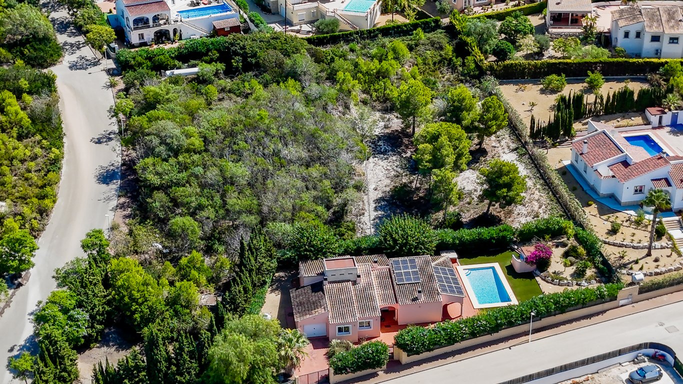 Luftaufnahme der Villa mit Solarmodulen auf dem Dach, privatem Pool und flachem Grundstück inmitten mediterraner Vegetation in Jávea.