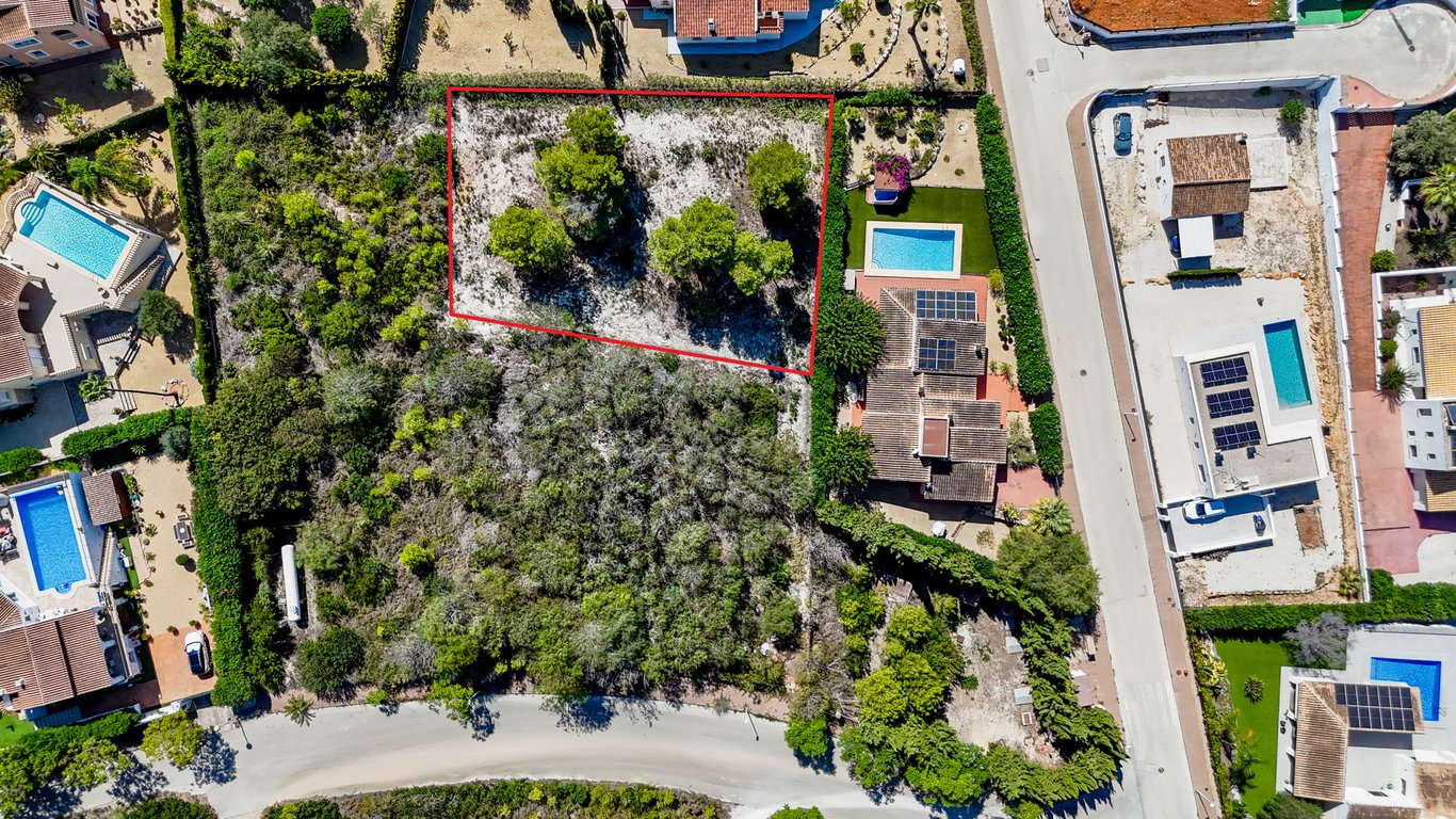 Luftaufnahme der Villa mit Solarmodulen und Pool sowie dem angrenzenden, rot markierten städtischen Baugrundstück in Jávea.