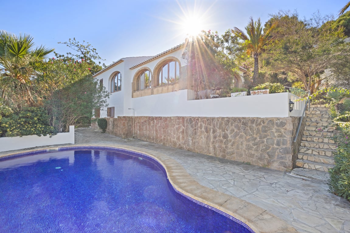 Außenansicht der Villa mit privatem Pool, Natursteinmauern und einer Naya mit Rundbögen aus traditionellem Tosca-Stein.
