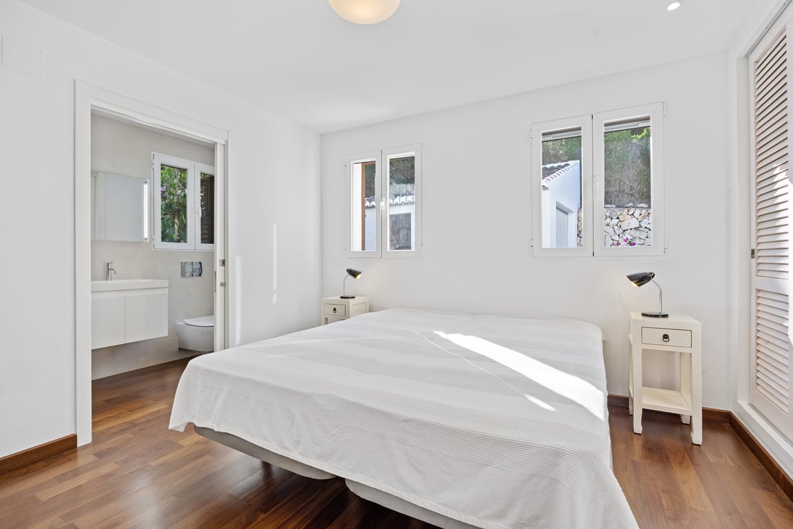 Helles Schlafzimmer mit Holzboden, modernisiertem En-Suite-Badezimmer und doppelt verglasten Fenstern, die für viel natürliches Licht sorgen.