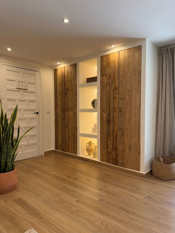 Einbauschrank mit rustikalen Holzfronten und integrierten LED-beleuchteten Regalnischen auf einem hochwertigen Keramikboden in Holzoptik.