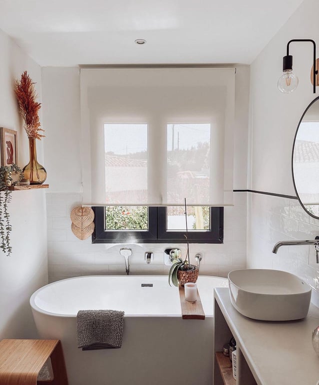 Modernes Badezimmer mit freistehender Badewanne, Aufsatzwaschbecken und schwarzem Fensterrahmen. Weiße Metro-Fliesen und Holzakzente schaffen ein helles Design.