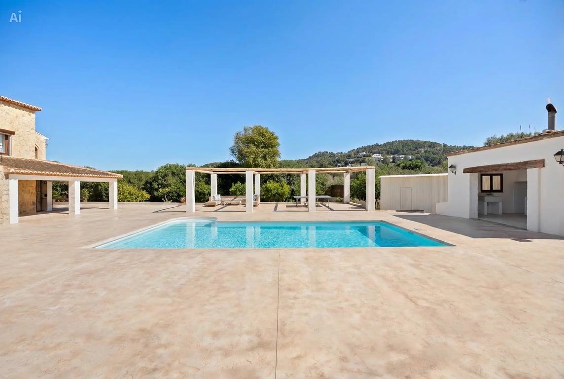 Ein 5x10 Meter großer Pool auf einer weitläufigen Terrasse mit Holzpergola, Außenküche und Panoramablick auf die umliegende Berglandschaft.
