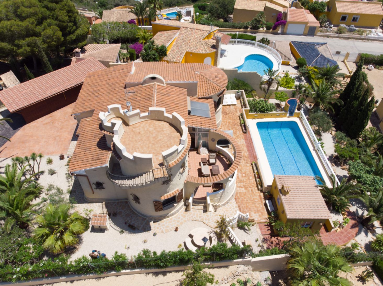 Luftaufnahme der Villa mit dem markanten Turm und Dachterrasse, dem 10x4 m großen Pool und den weitläufigen Außenanlagen auf dem 1.030 m² großen Grundstück.