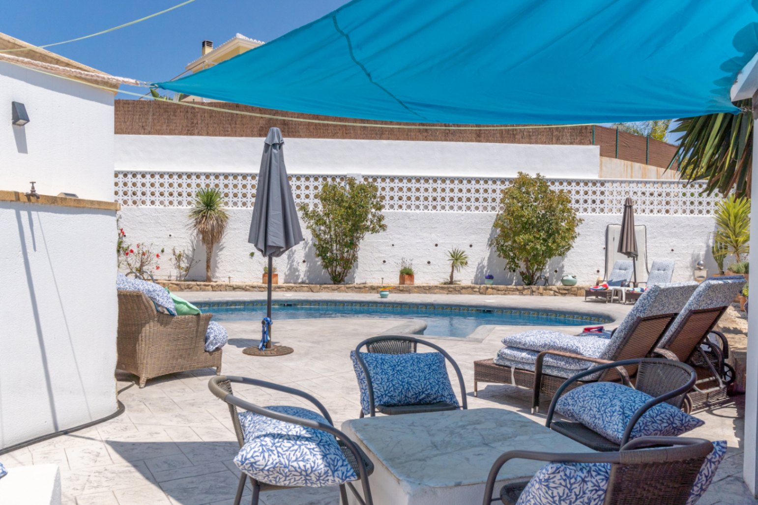 Poolblick mit blauer Markise und Gartenmöbeln in Villa in Jávea.