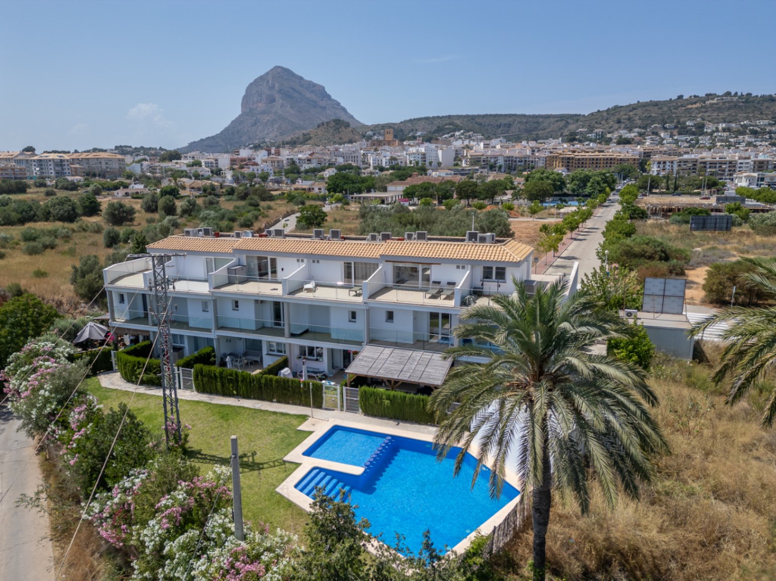 Luftaufnahme der modernen Wohnanlage mit Gemeinschaftspool, privaten Terrassen und Blick auf den Berg Montgó und die Altstadt von Jávea.