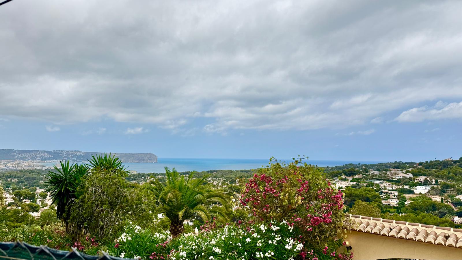 Panoramablick auf das Mittelmeer und das Cabo de San Antonio, eingerahmt von üppigen mediterranen Gärten und einheimischer Flora.