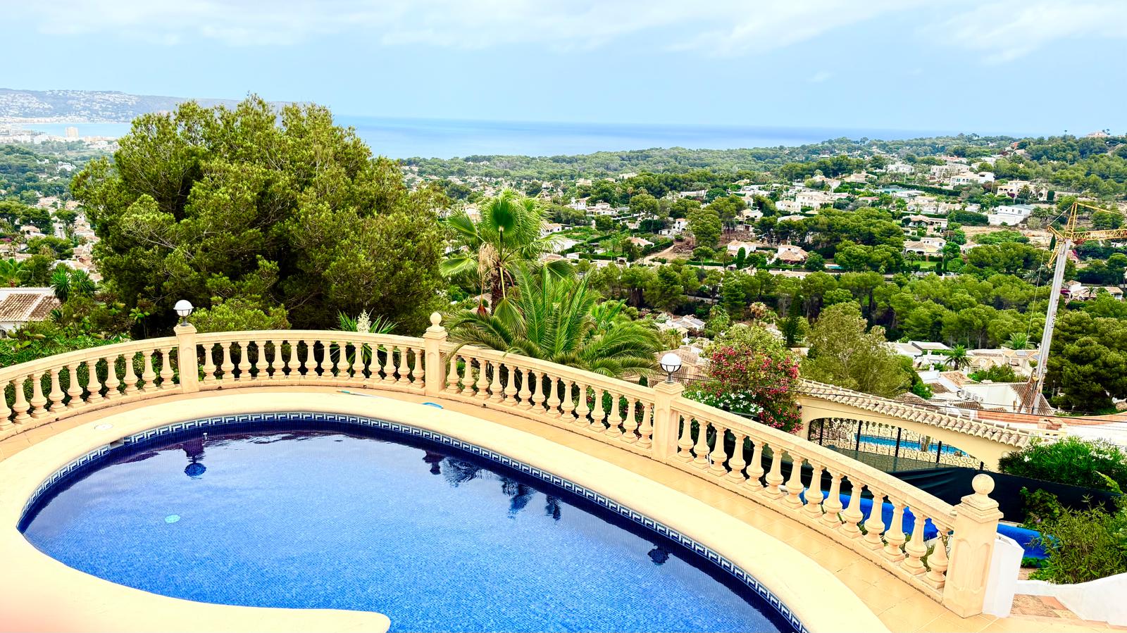 Privater 12x6 m Pool mit klassischer Balustrade und Panoramablick auf das Mittelmeer und die Küste von Jávea von einer erhöhten Terrasse aus.