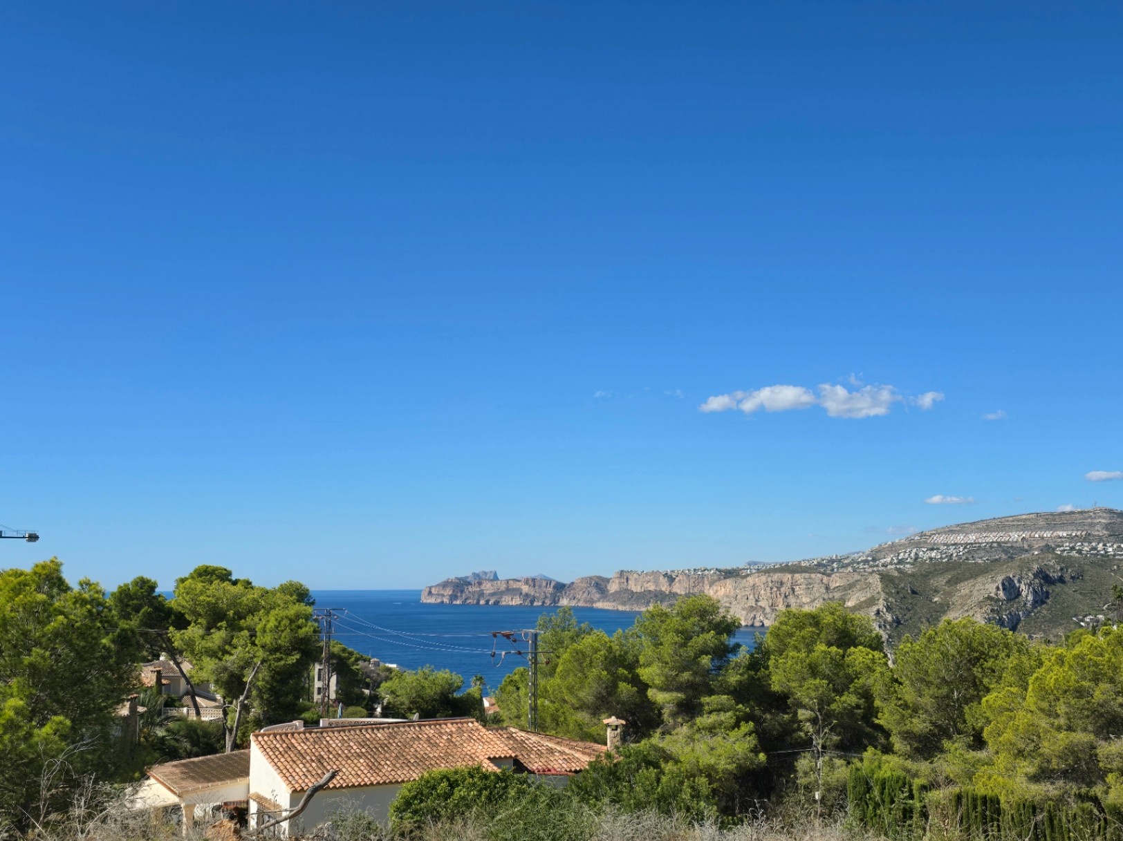 Panoramablick auf das Mittelmeer und die Klippen von Jávea vom erhöhten Grundstück aus, umgeben von Pinien und einheimischer Vegetation.