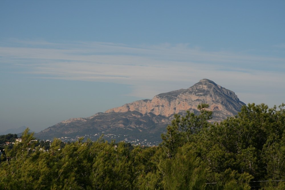 Panoramablick auf das Montgó-Massiv vom Grundstück aus, mit markanten Felswänden über einem Vordergrund aus mediterranen Pinien.