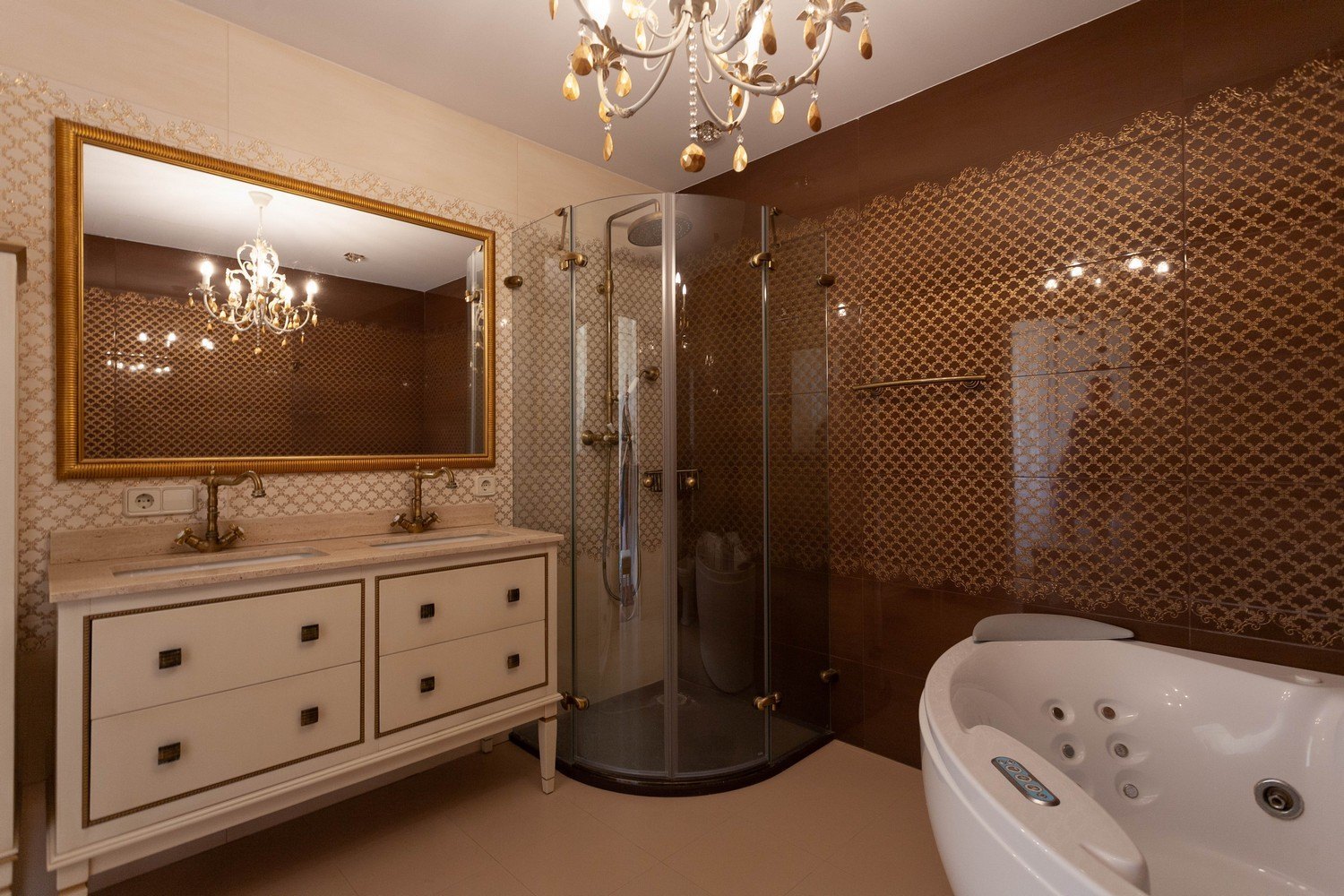 Badezimmerdetail mit Doppelwaschtisch, Eckdusche und Whirlpool. Elegante Kronleuchterbeleuchtung.