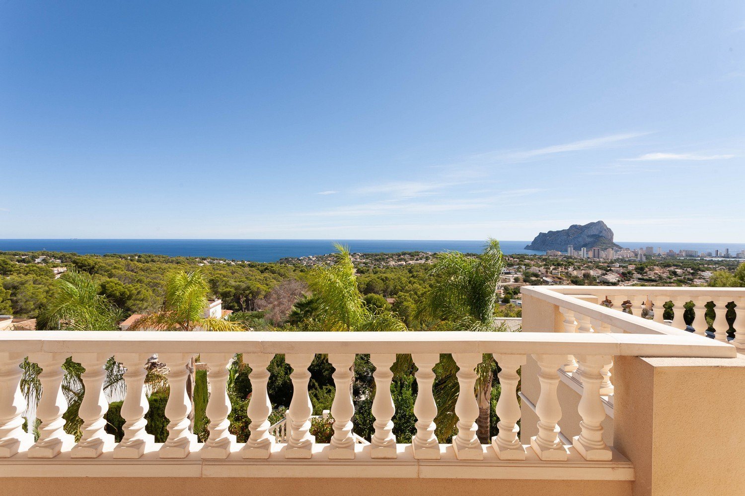 Blick von der Terrasse mit steinerner Balustrade auf das Meer und den Peñón de Ifach.