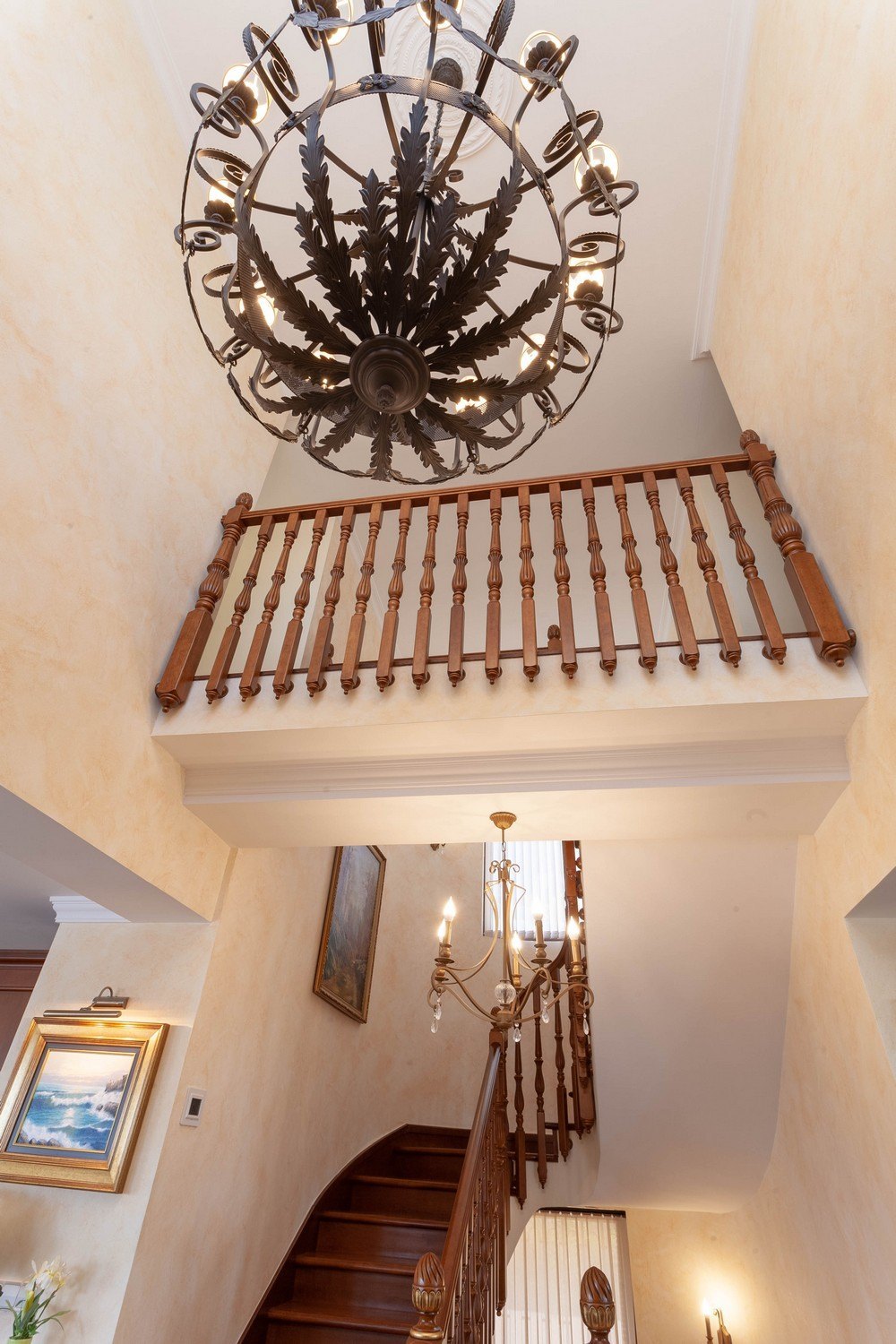 Detail der Holztreppe mit Geländer und dekorativem Kronleuchter.