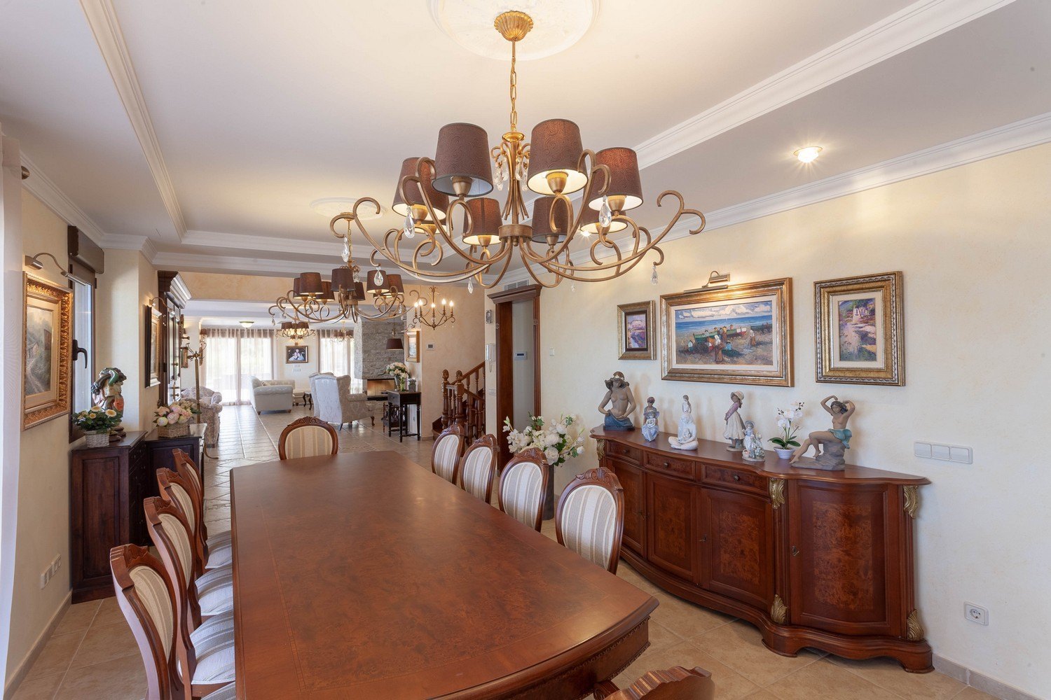 Formales Esszimmer mit dunklem Holztisch, gepolsterten Stühlen und klassischem Sideboard mit goldenen Akzenten.