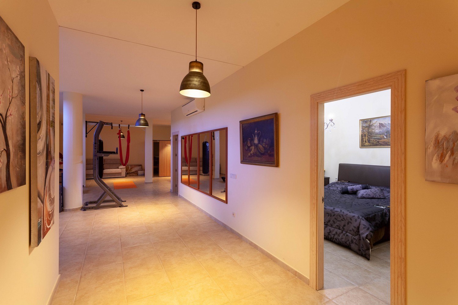 Helles Interieur mit Fitnessraum, Saunazugang und Schlafzimmereingang. Fliesenboden und klassisches Dekor.