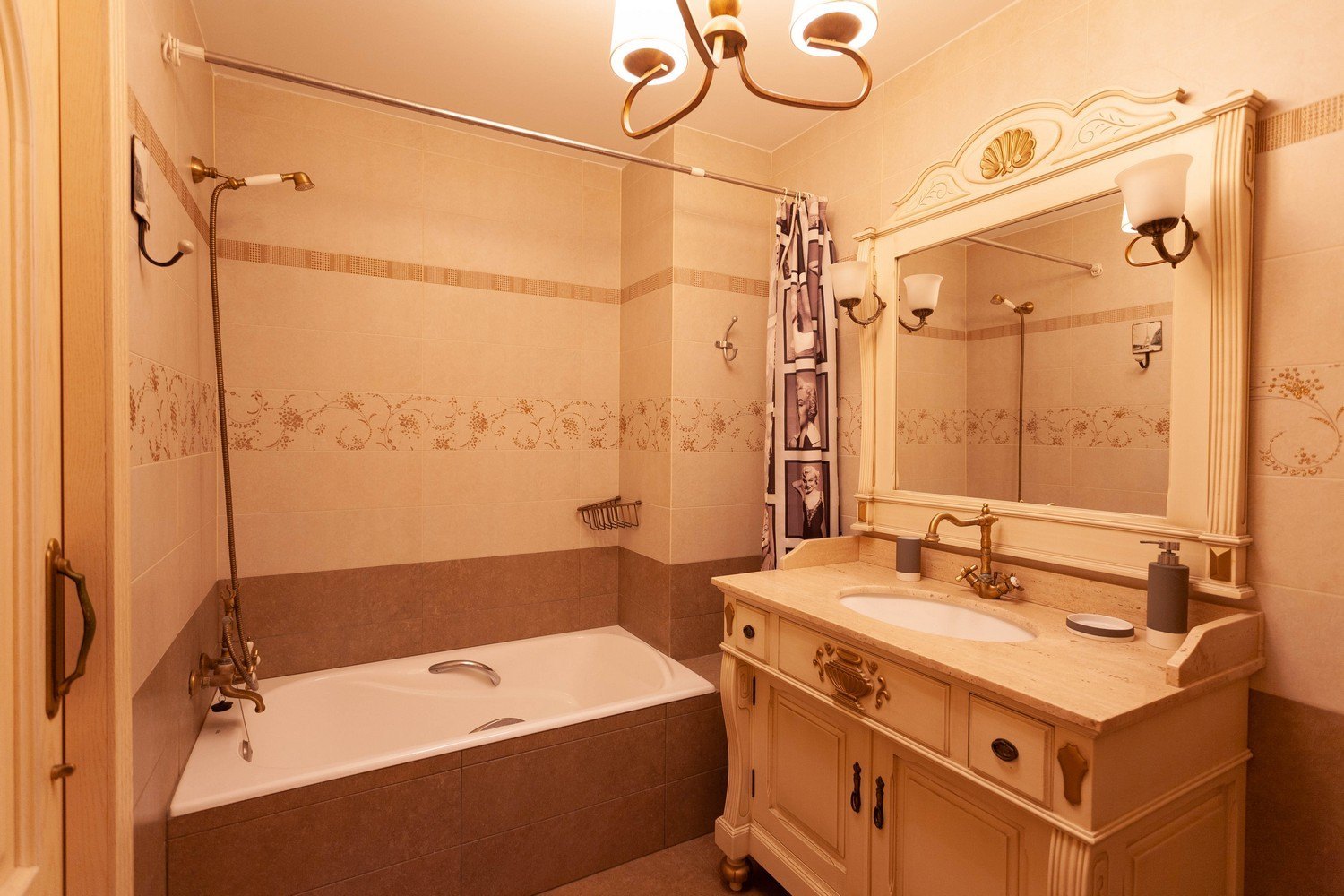 Klassisches Badezimmer mit Badewanne, Waschtisch mit Marmorplatte und verziertem Spiegel.