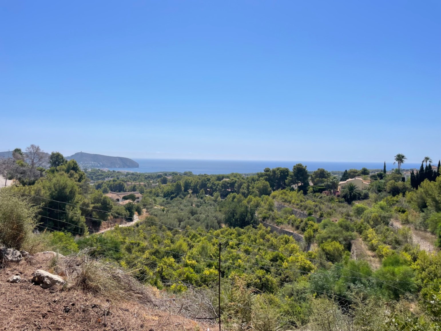 Panoramablick vom Grundstück auf das Mittelmeer und Cap d'Or, eingebettet in eine grüne Hügellandschaft mit Pinien und mediterraner Flora in Benimeit.