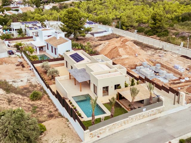 Luftaufnahme der modernen Villa mit Solaranlage auf dem Dach, privatem Pool und angelegtem Garten in der exklusiven Wohngegend von Jávea.