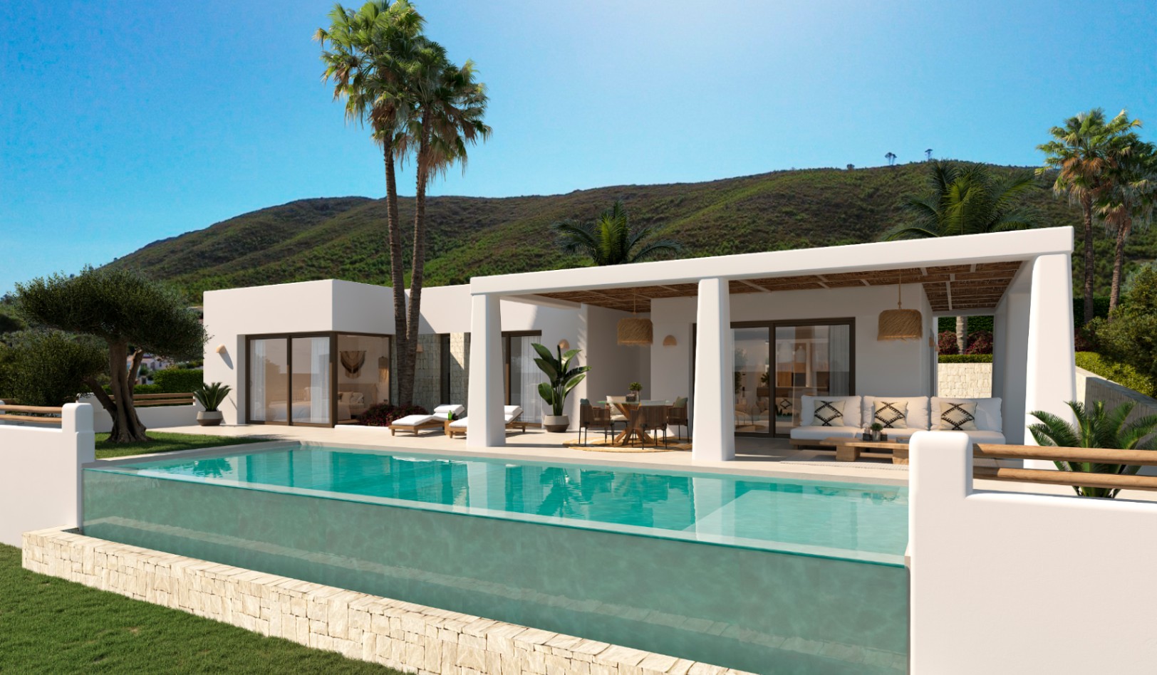 Außenansicht der Villa mit Glaswand-Infinity-Pool, überdachter Terrasse mit Schilfdecke und weißer ibizenkischer Architektur vor einer Bergkulisse.