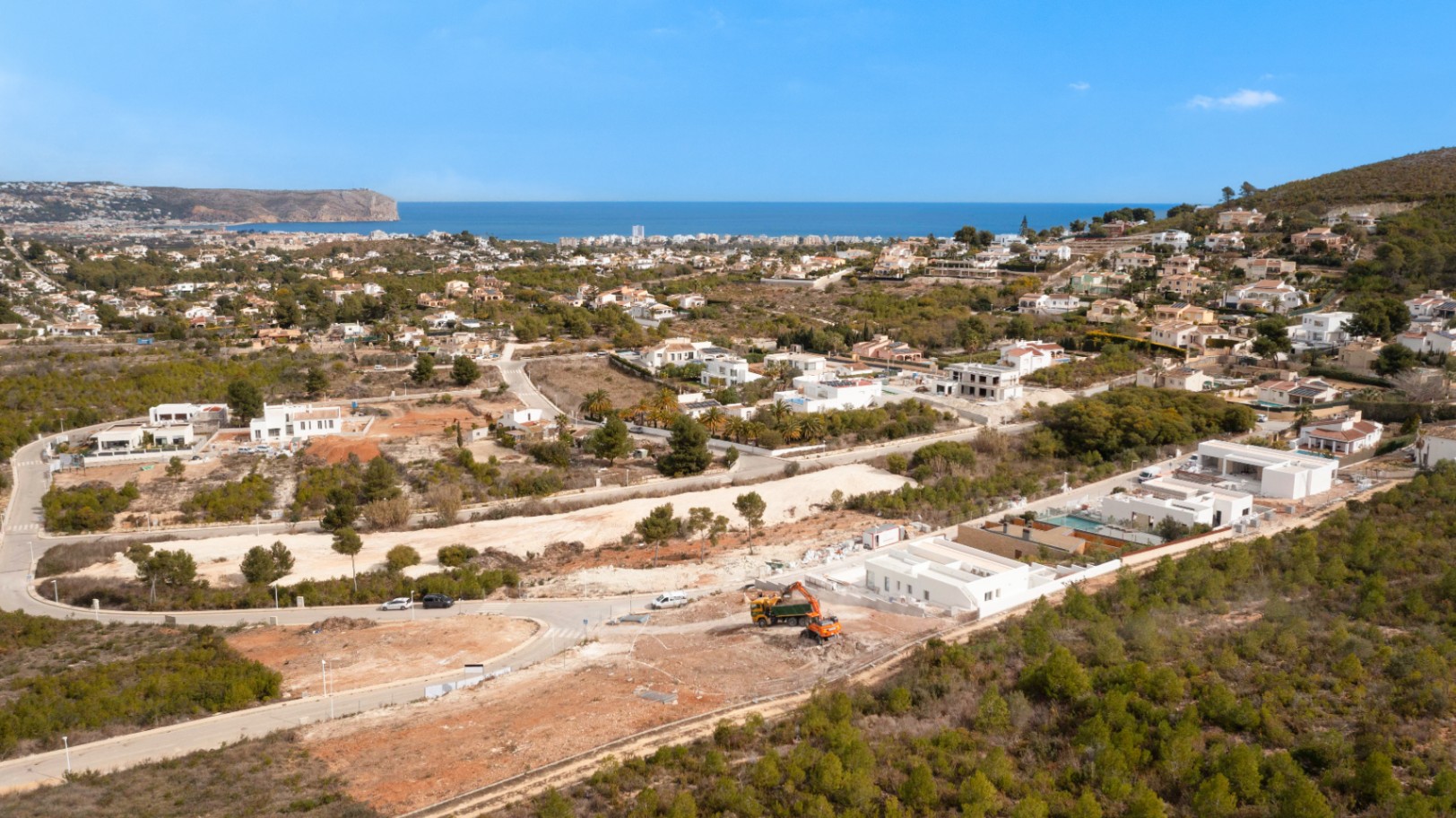 Luftaufnahme des Grundstücks in Lomas Del Rey, Jávea, mit beginnenden Erdarbeiten und weitem Blick über das Mittelmeer und die Küste.