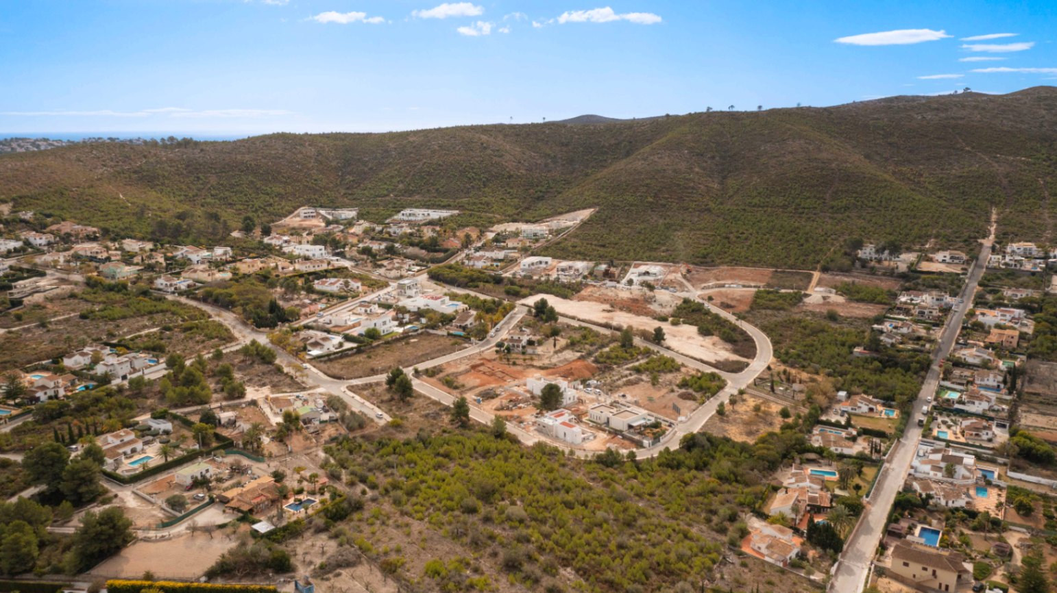 Luftaufnahme des Wohngebiets Lomas Del Rey in Jávea, die Grundstücke und Villen inmitten mediterraner Hügel und Pinienwälder zeigt.