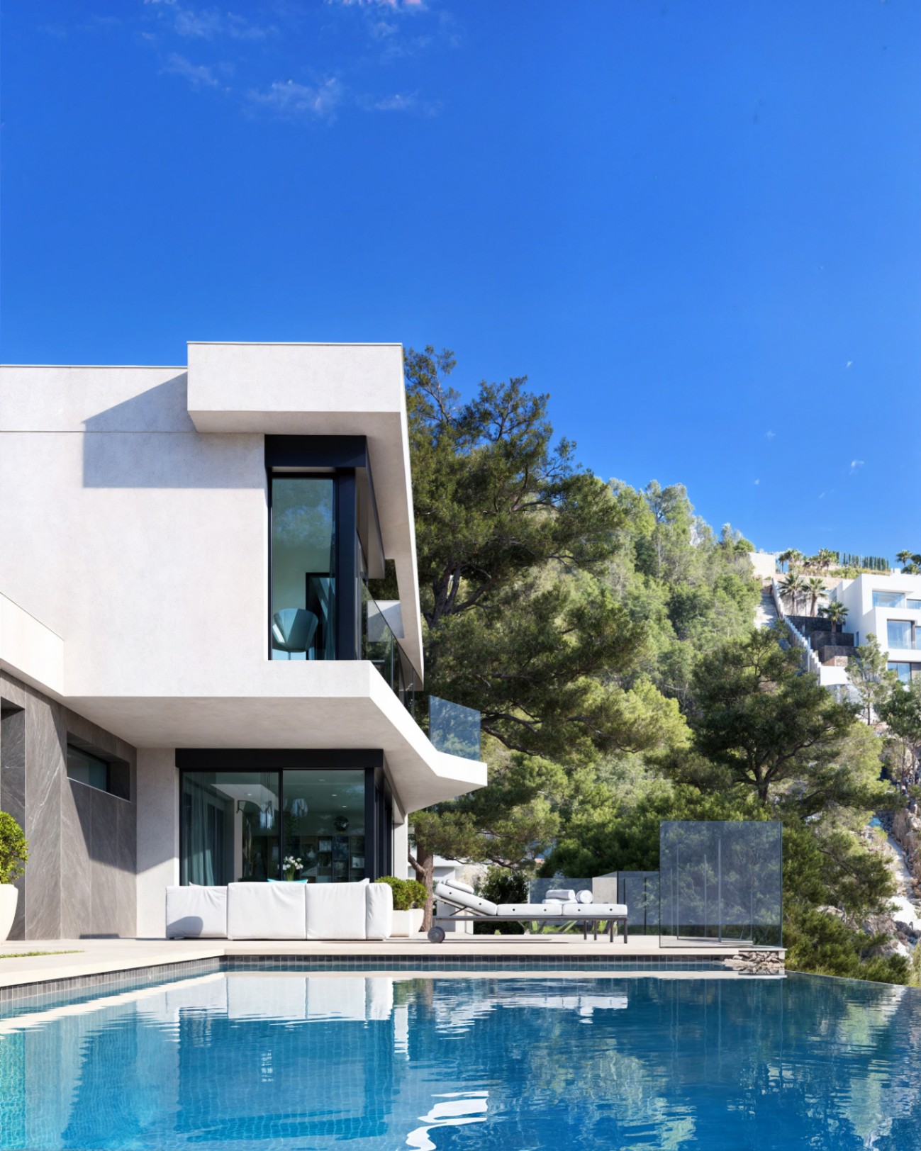 Moderne Fassade mit weißen Auskragungen, Infinity-Pool und Terrasse mit Designermöbeln, eingebettet in eine mediterrane Pinienlandschaft.