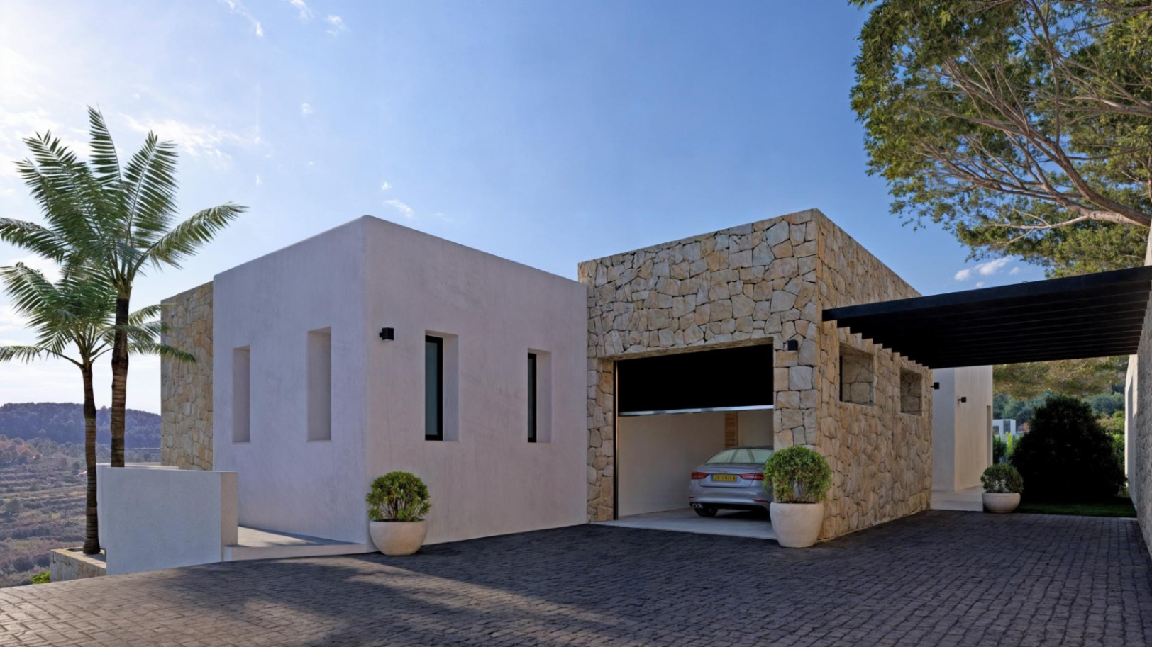 Modernes Äußeres mit steinverkleideter Garage und grau gepflasterter Auffahrt.