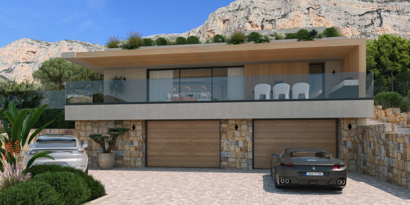 Außenfassade mit Natursteinwänden, Doppelgarage mit Holztoren und einer großzügigen Terrasse mit Glasgeländer vor der Kulisse des Montgó-Massivs.