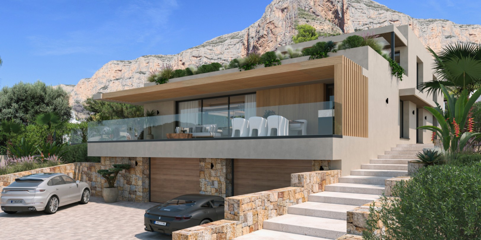 Moderne Außenfassade mit Natursteinwänden, Doppelgarage und einer großzügigen Terrasse mit Glasgeländer vor der Kulisse des Montgó-Massivs.