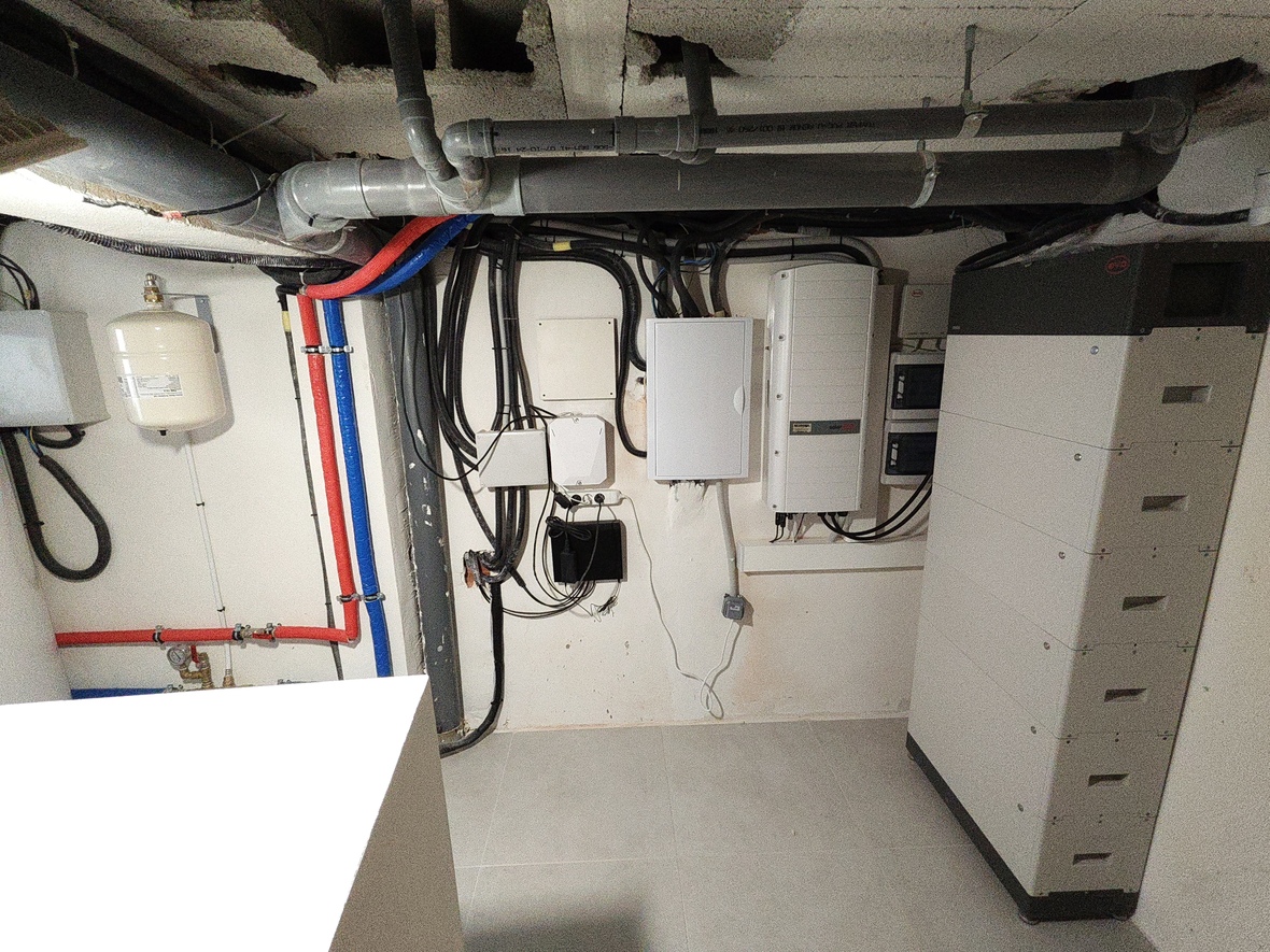 Technikraum mit SolarEdge-Wechselrichter, BYD-Batteriespeichersystem und strukturierter Sanitärinstallation inklusive Ausdehnungsgefäß und PEX-Rohren.