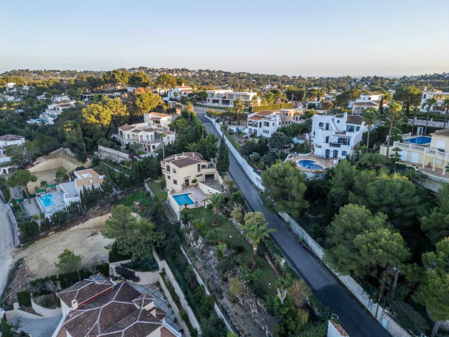Luftaufnahme des Wohngebiets Costa Nova Panorama mit mediterranen Villen, privaten Pools und üppiger Vegetation auf den Hügeln von Jávea.