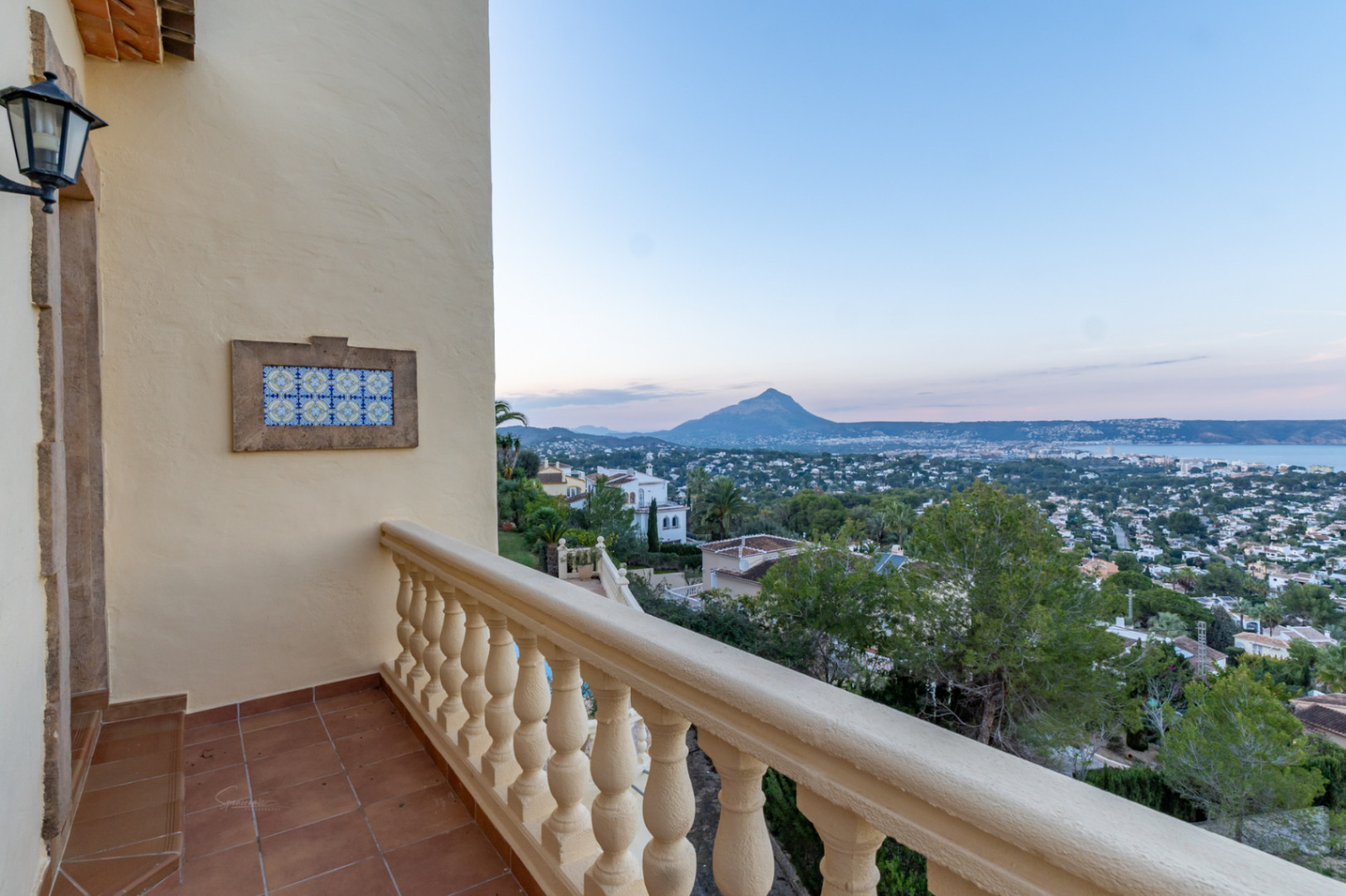 Terrasse mit Terrakottaboden und Balustrade, die einen weiten Blick über die Bucht von Jávea und das Montgó-Massiv bietet.
