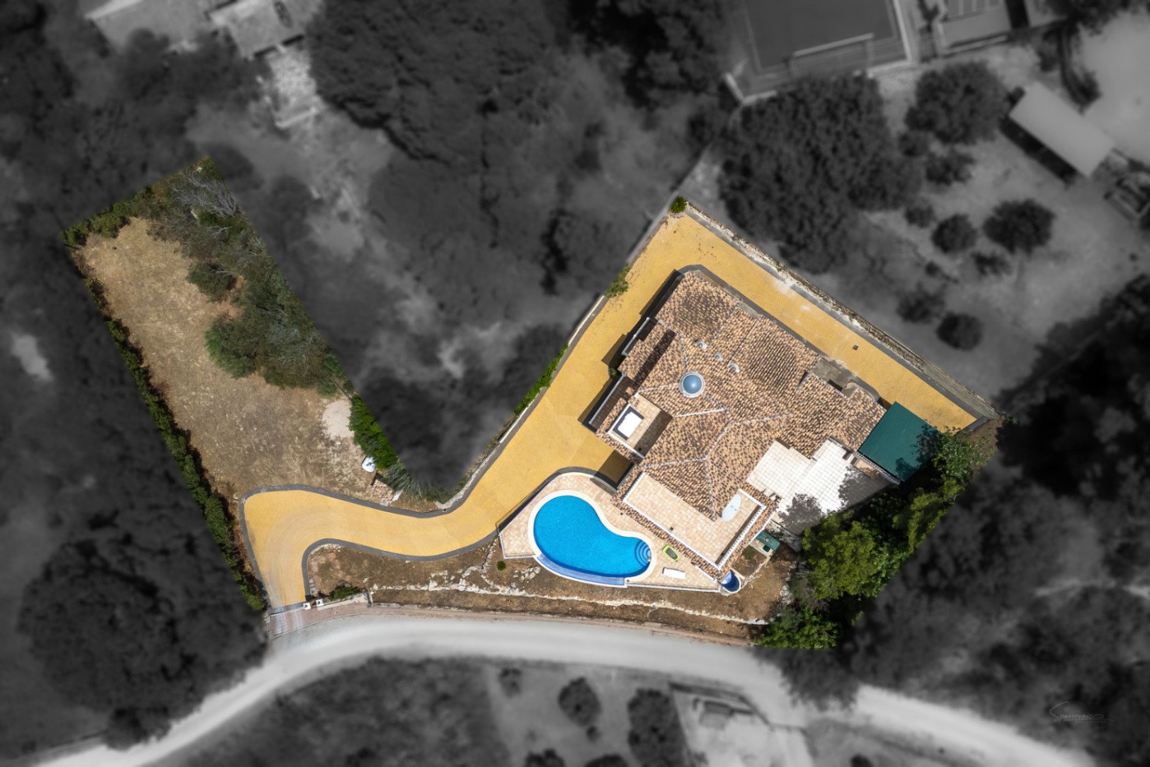 Luftaufnahme der Villa mit Fokus auf den Infinity-Pool, das traditionelle Ziegeldach mit zentraler Glaskuppel und die großzügige gepflasterte Einfahrt in erhöhter Lage.