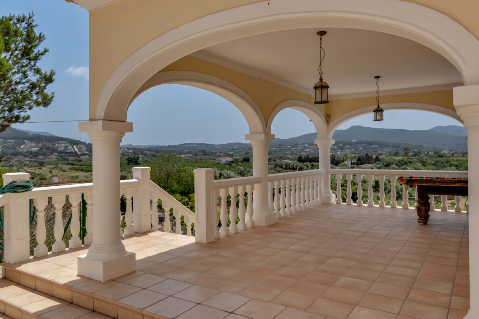 Überdachte Naya mit Rundbögen, weißen Säulen und Balustradengeländer. Ausgestattet mit Terrakotta-Fliesen, Billardtisch und weitem Blick über das Tal.