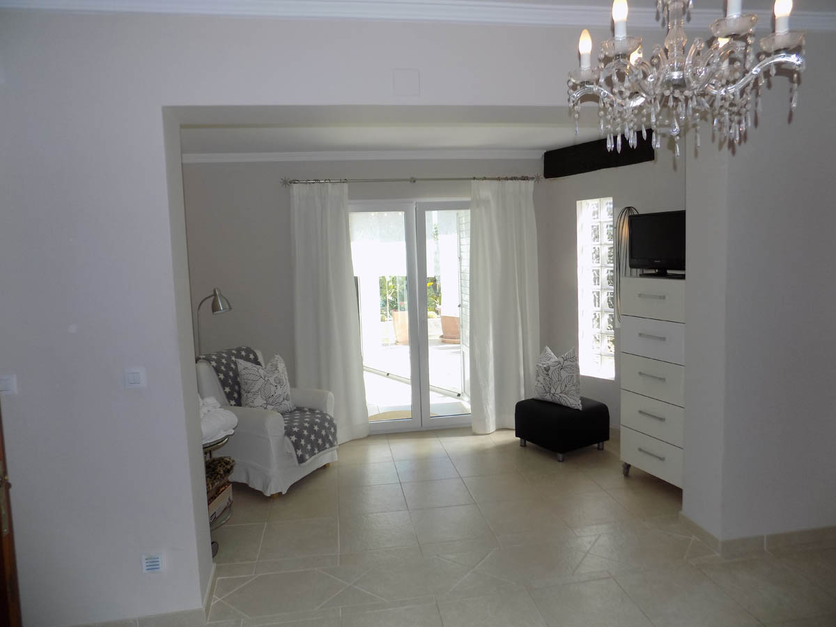 Heller Sitzbereich mit Fliesenboden, direktem Zugang zur Terrasse und Glasbausteinen für optimalen Lichteinfall.