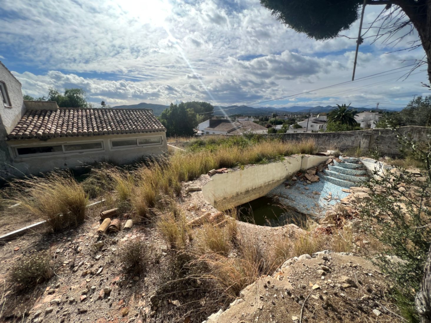 Renovierungsbedürftiger Pool mit römischer Treppe auf einem weitläufigen Grundstück mit freiem Blick auf die umliegende Berglandschaft von Jávea.