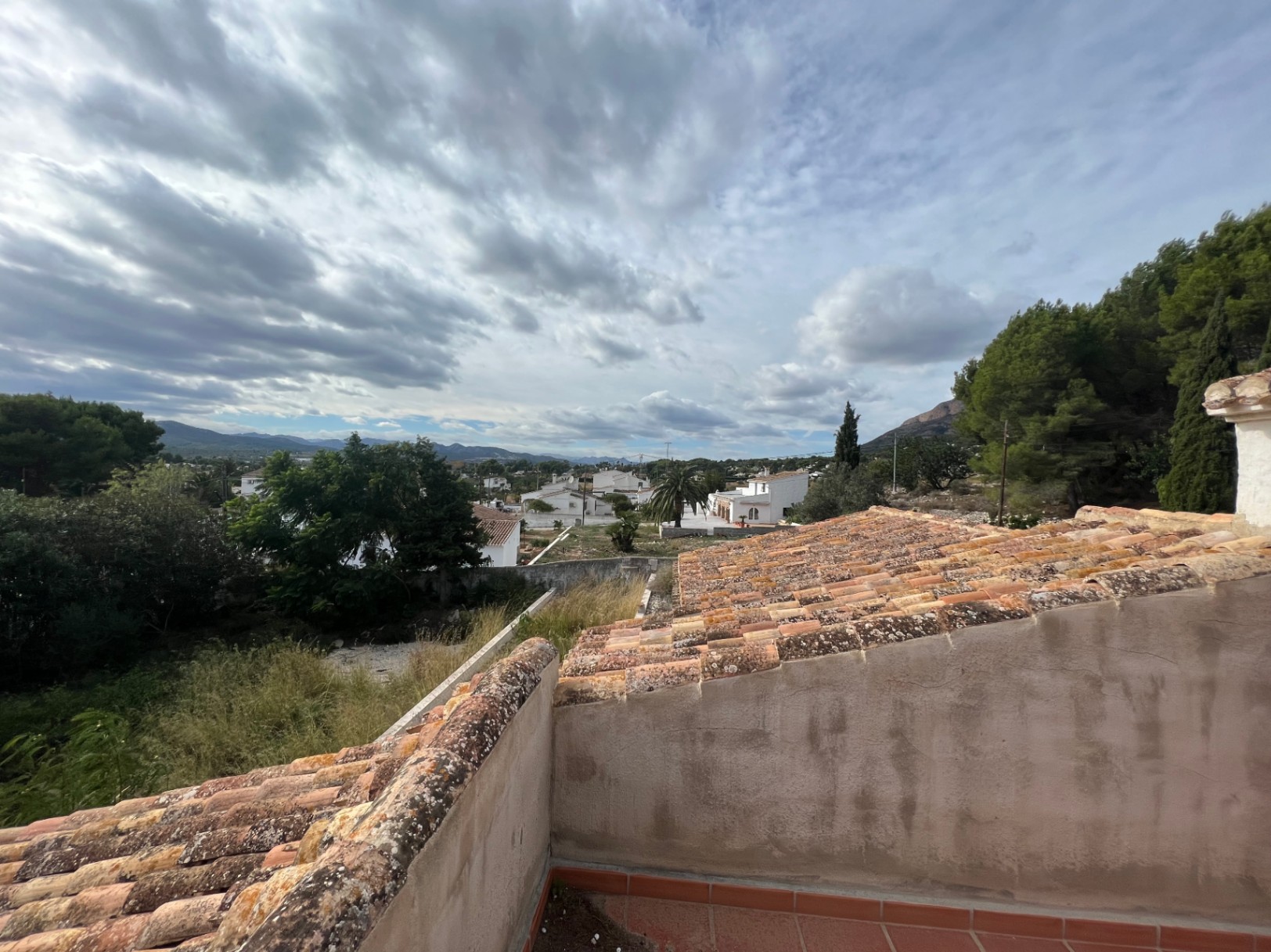 Weitläufiger Blick von der oberen Terrasse über das Montgó-Tal, mit traditionellen Ziegeldächern und der grünen mediterranen Umgebung von Jávea.
