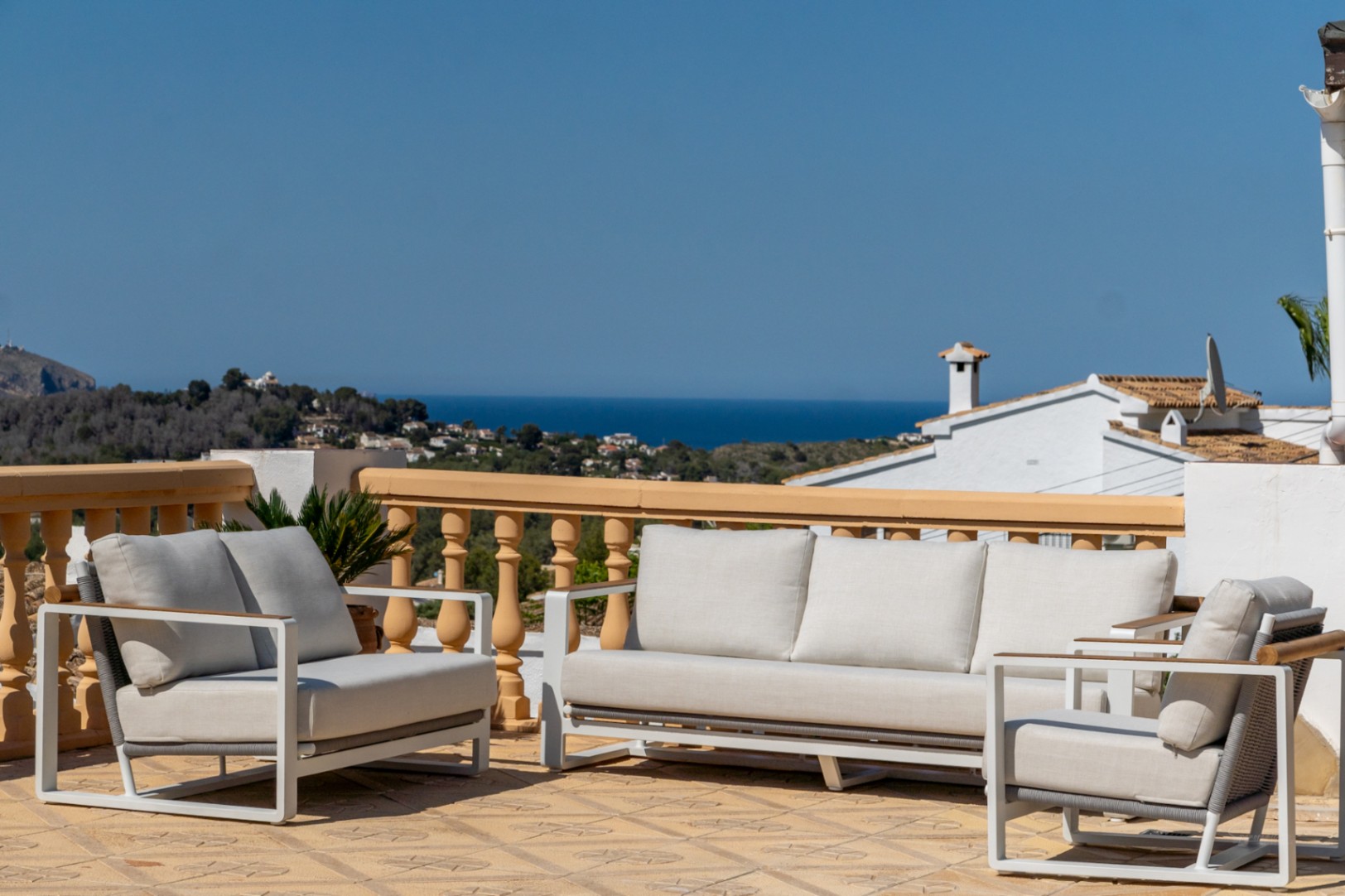 Hochgelegene Terrasse mit modernen Loungemöbeln und Panoramablick auf das Mittelmeer und die Küstenlandschaft von Jávea.